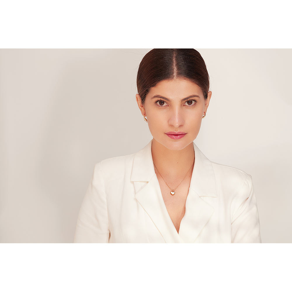 Woman wearing a white blazer against a plain background