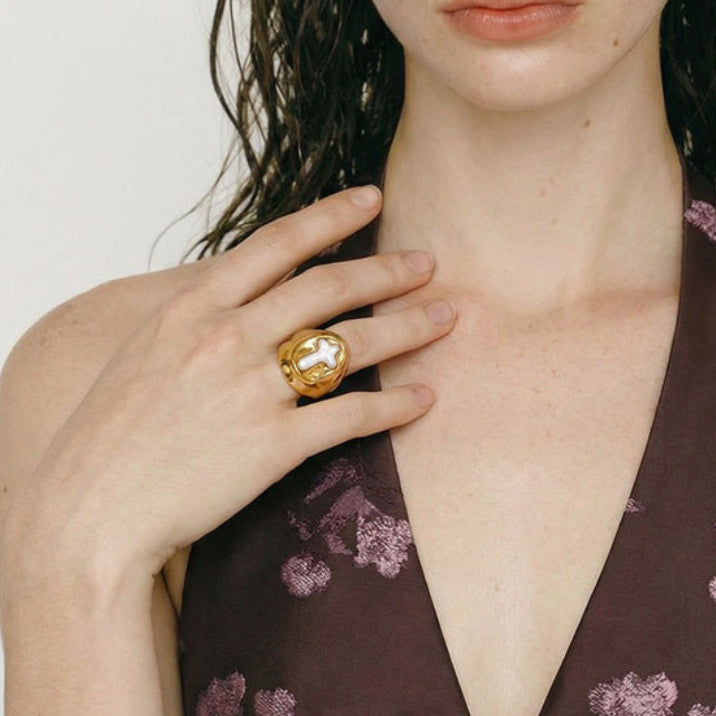 Woman wearing a floral dress with a bold gold ring