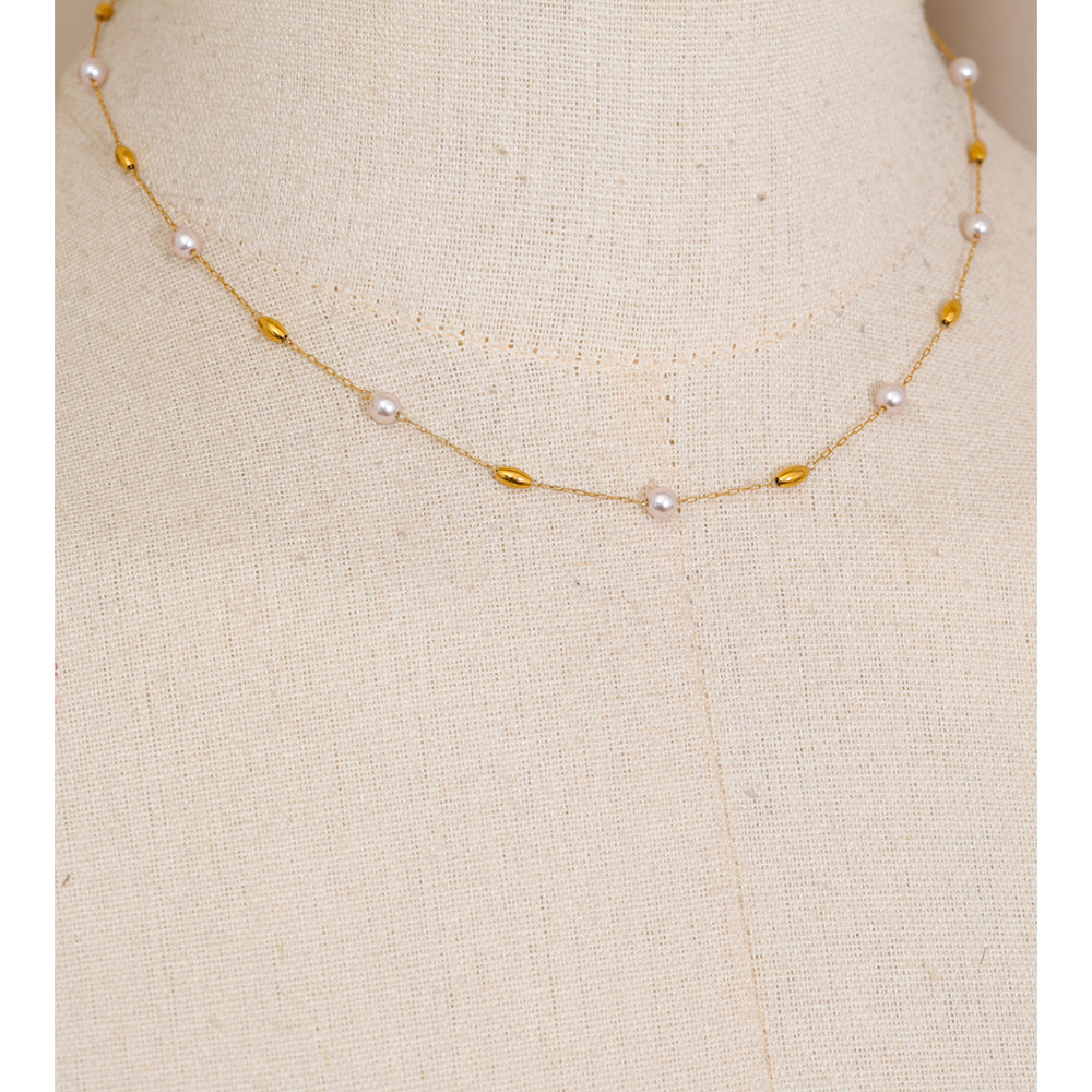 Necklace with pearls and gold beads on a mannequin bust.