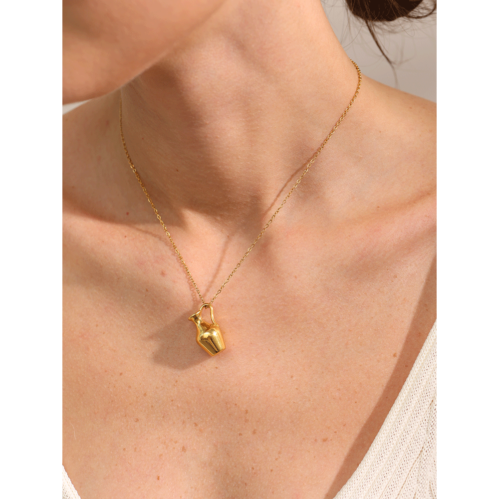 Gold necklace with a vase pendant on a person's neck