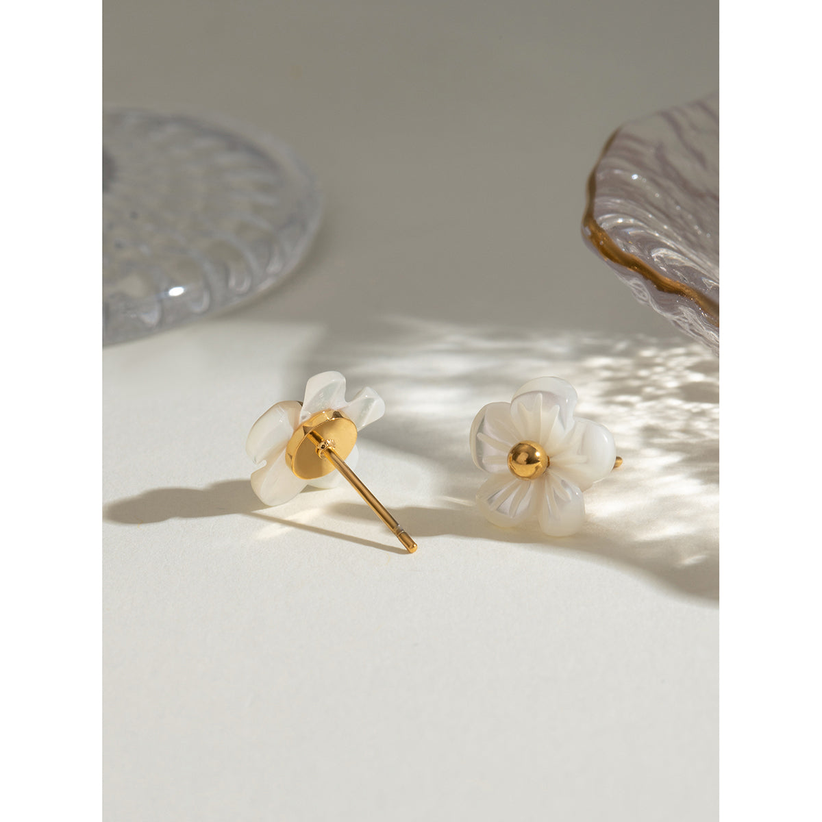 Flower earrings with gold accents on a light surface