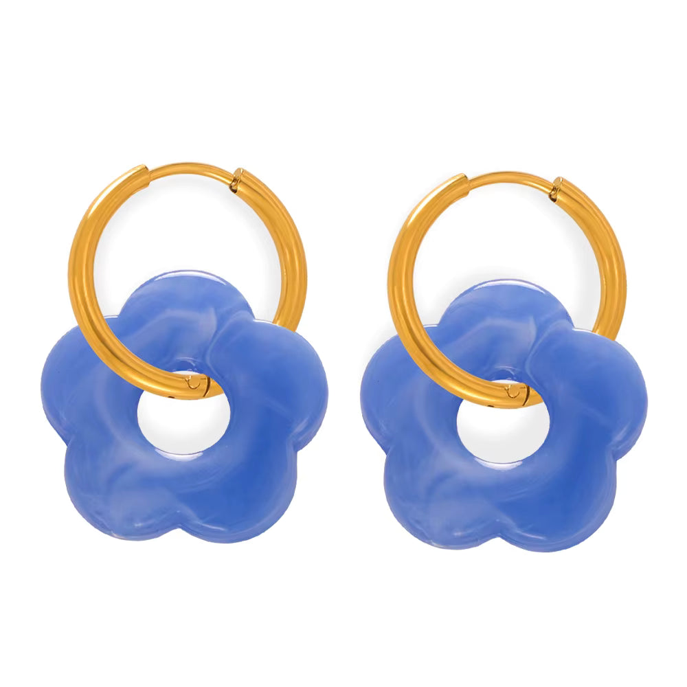 Pair of hoop earrings with blue flower-shaped connectors on a white background