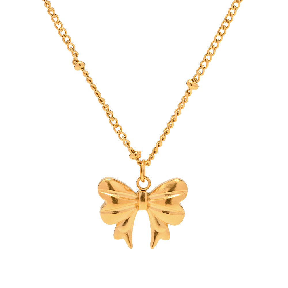 Gold bow-shaped pendant on a chain against a white background