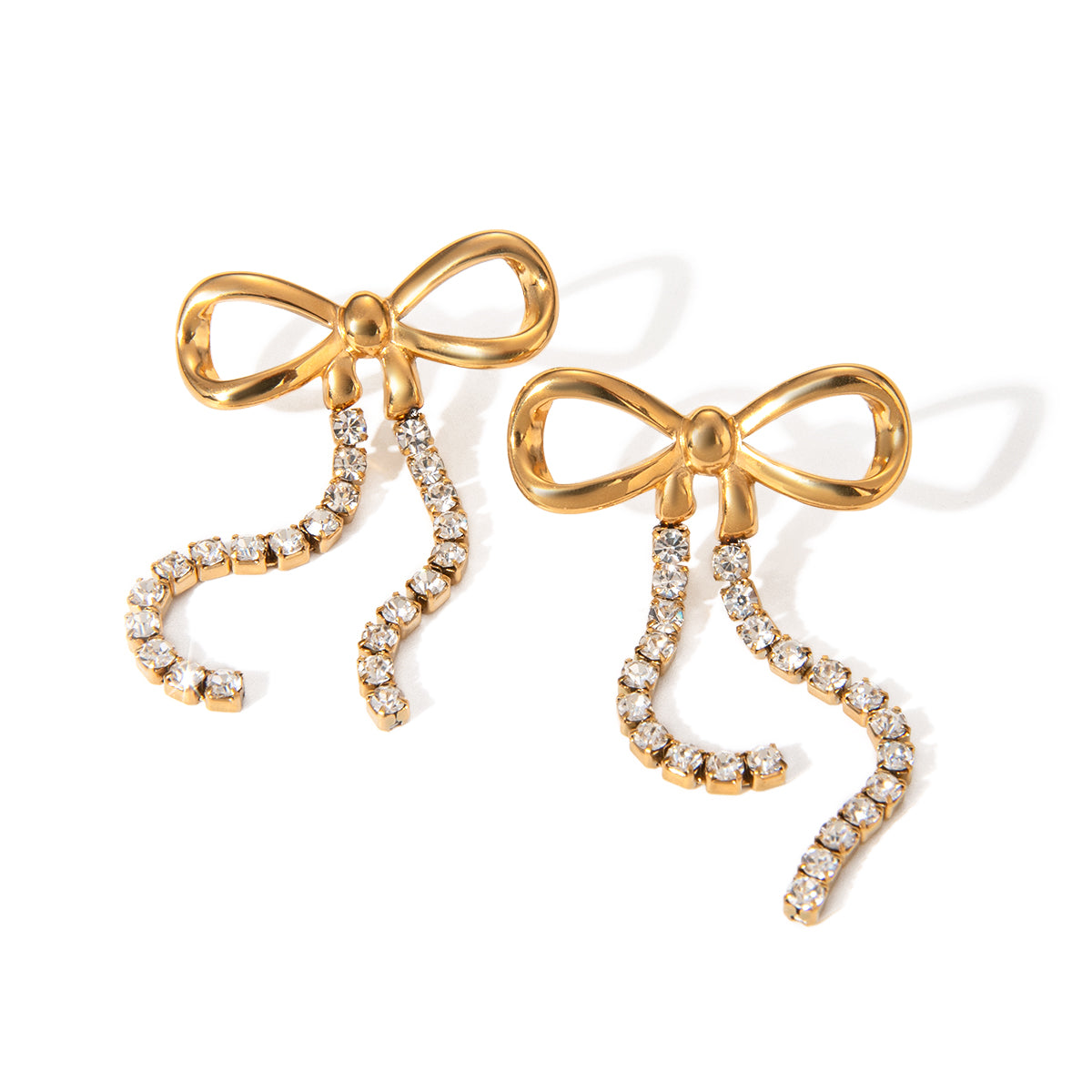 Gold bow-shaped earrings with diamond accents on a white background