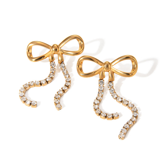 Gold bow-shaped earrings with diamond accents on a white background