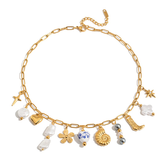 Gold necklace with various charms on a white background