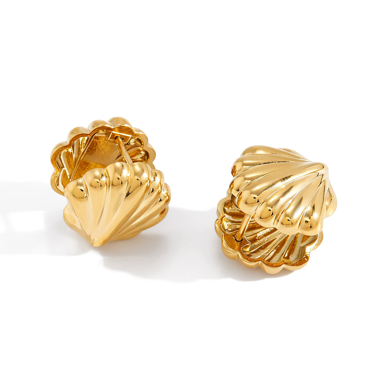 Pair of gold shell-shaped earrings on a white background