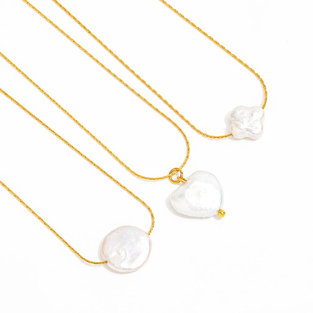 Three gold necklaces with white pearls on a white background
