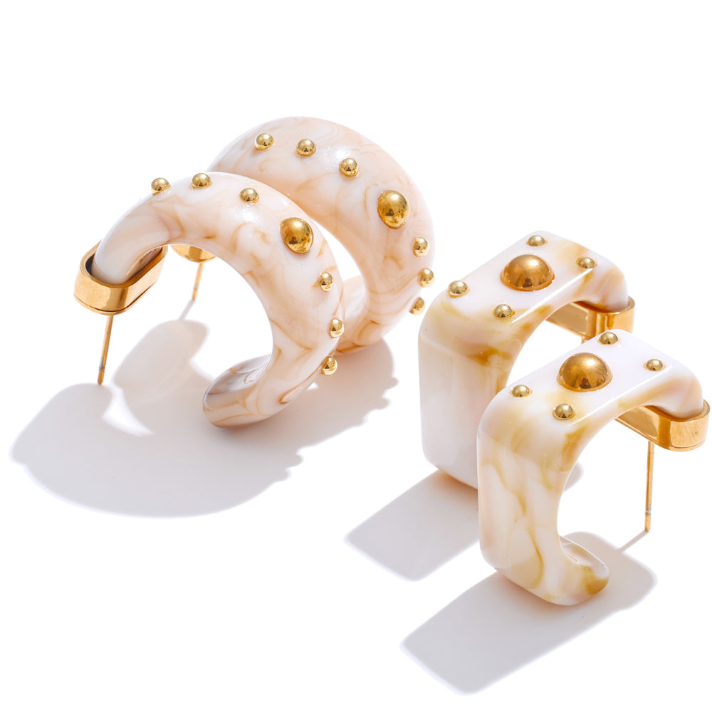 Pair of gold and beige hoop earrings on a white background