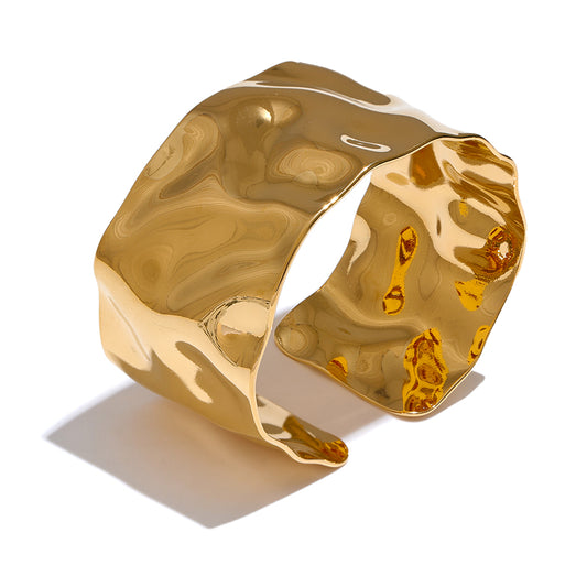 Gold bangle with a marbled texture on a white background