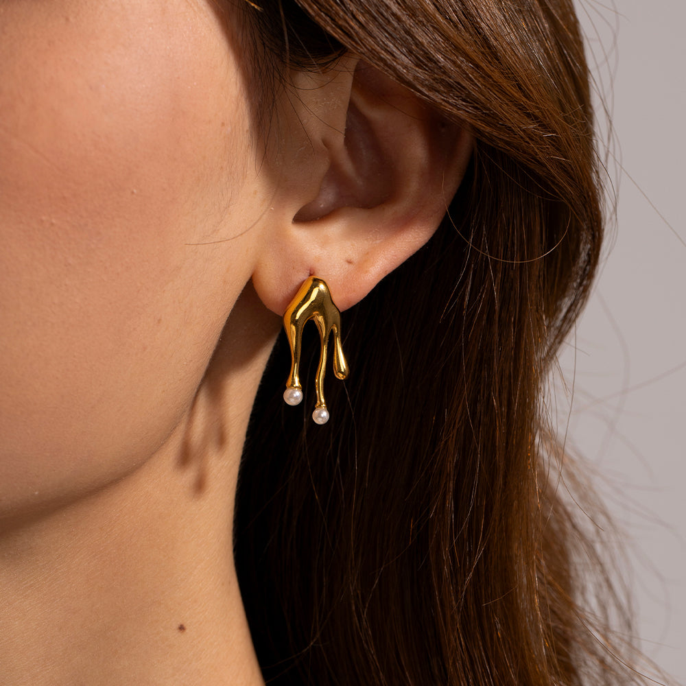 Melted Gold earring with pearl drops worn by a person