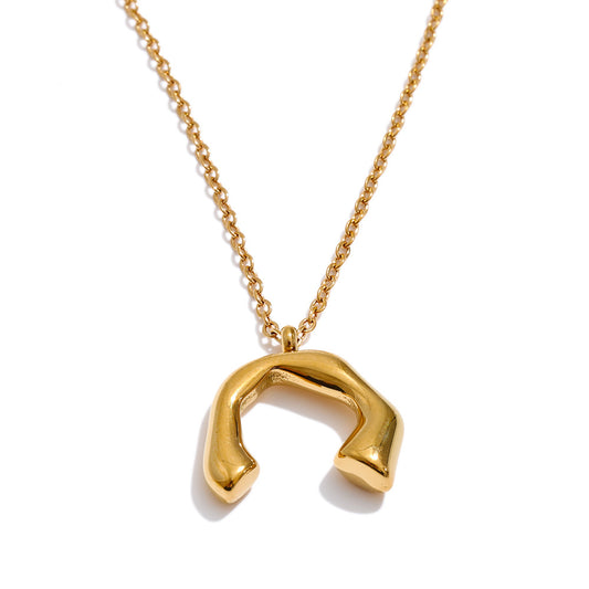 Elisa Necklace with a sculptural, open horseshoe-shaped 18K gold-plated pendant on a delicate chain against a white background