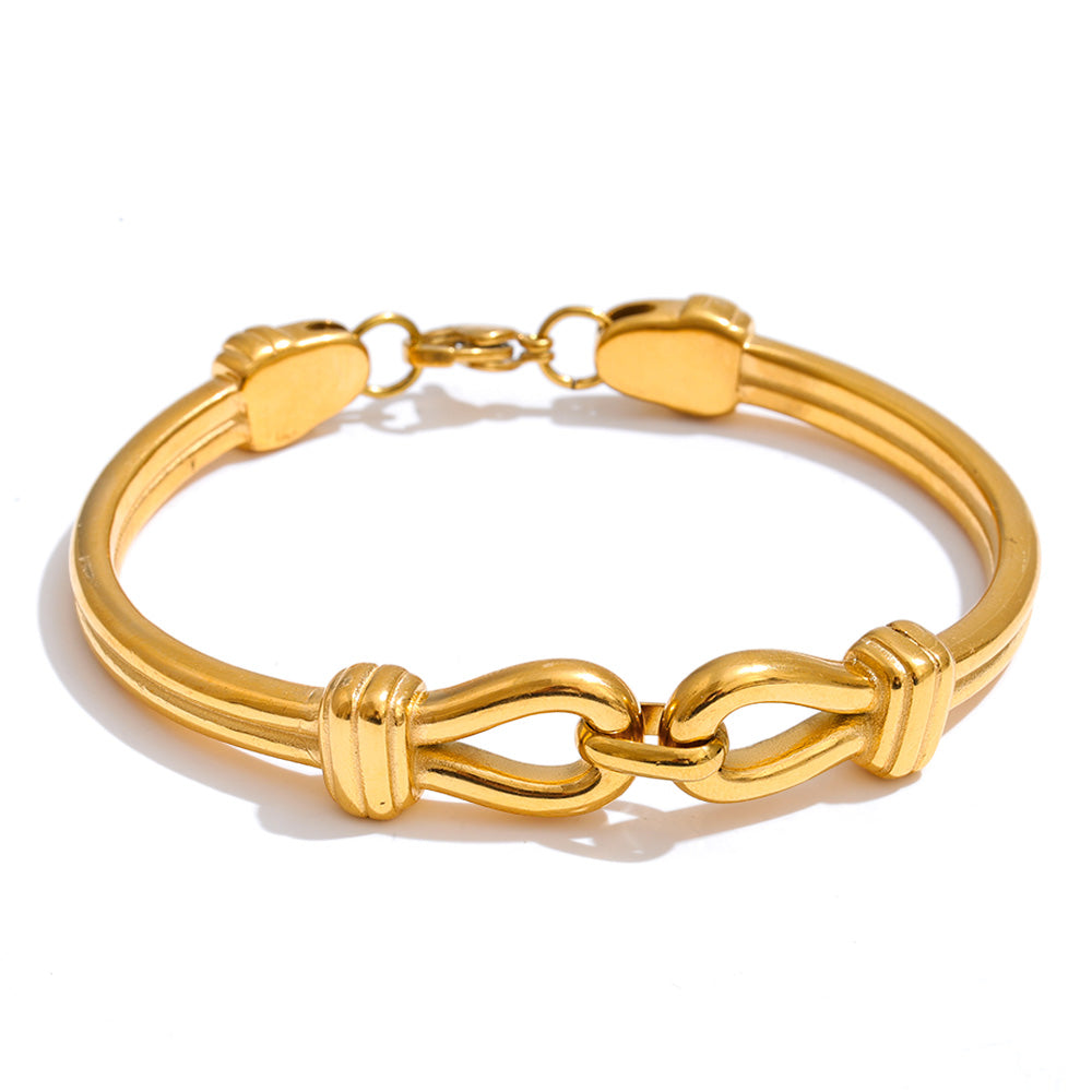Gold bracelet with interlocking design on a white background
