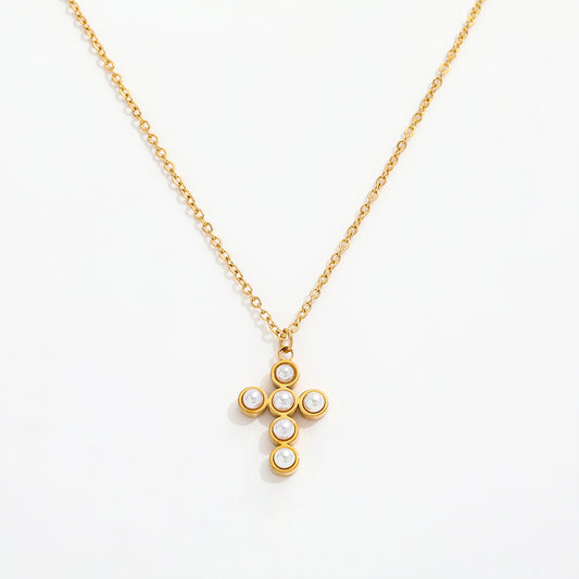 Gold necklace with a cross pendant featuring pearls on a white background