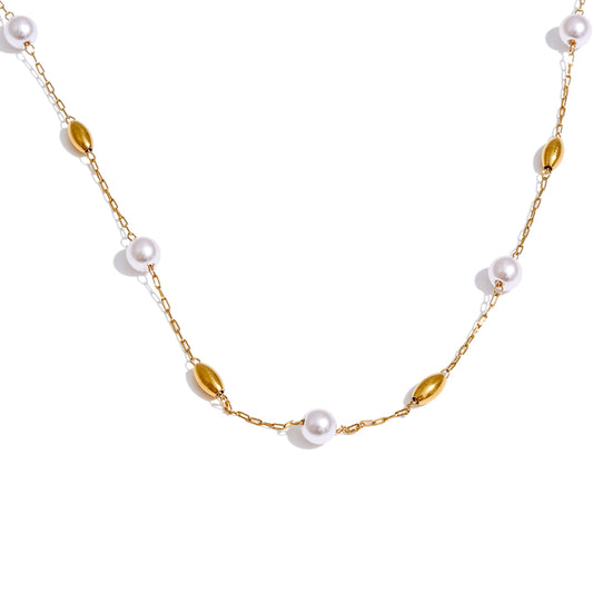 Gold chain necklace with pearls on a white background