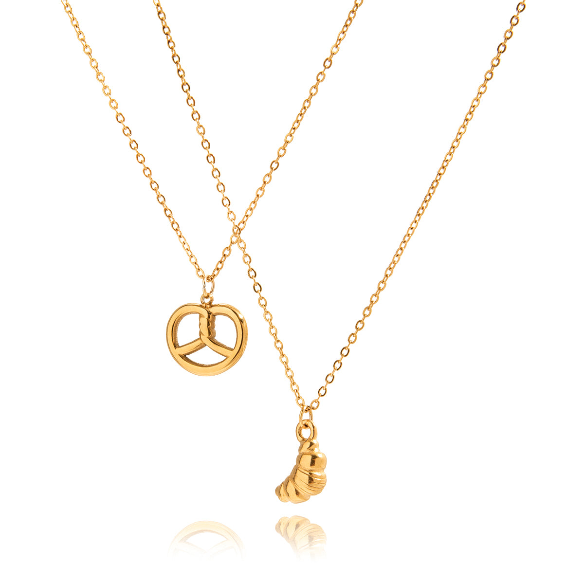Two gold necklaces with pretzel pendant and croissant pendant on a white background