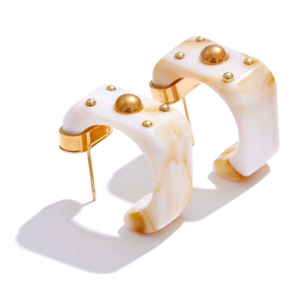 White and gold ring with gold hoops on a white background