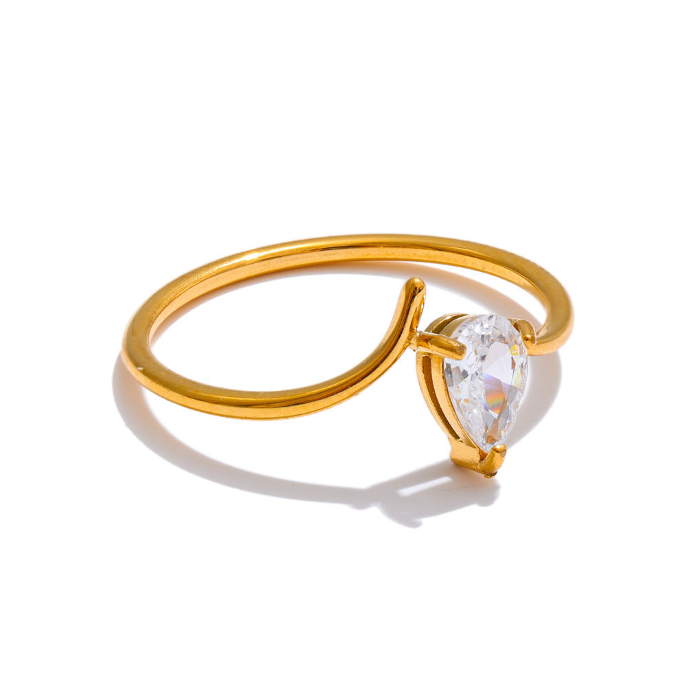 Gold ring with a teardrop-shaped diamond on a white background