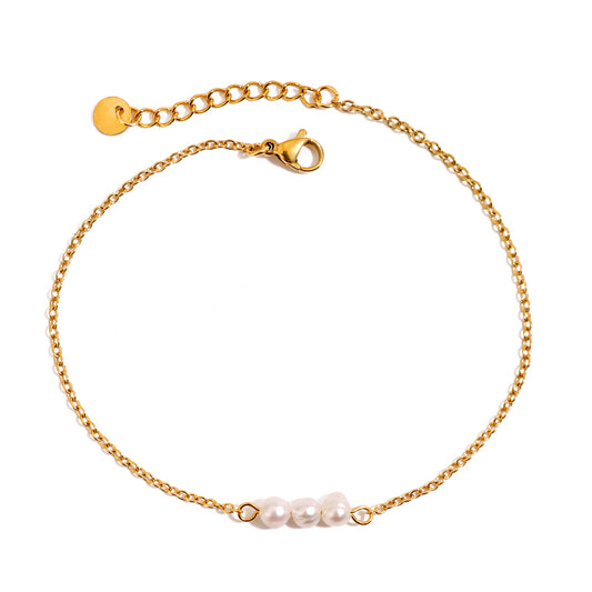 Gold anklet with pearls on a white background