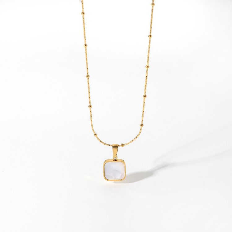 Gold necklace with a square pendant on a white background