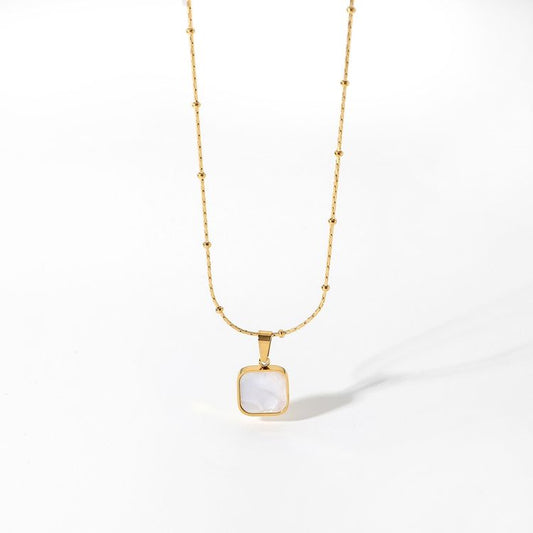 Gold necklace with a square pendant on a white background