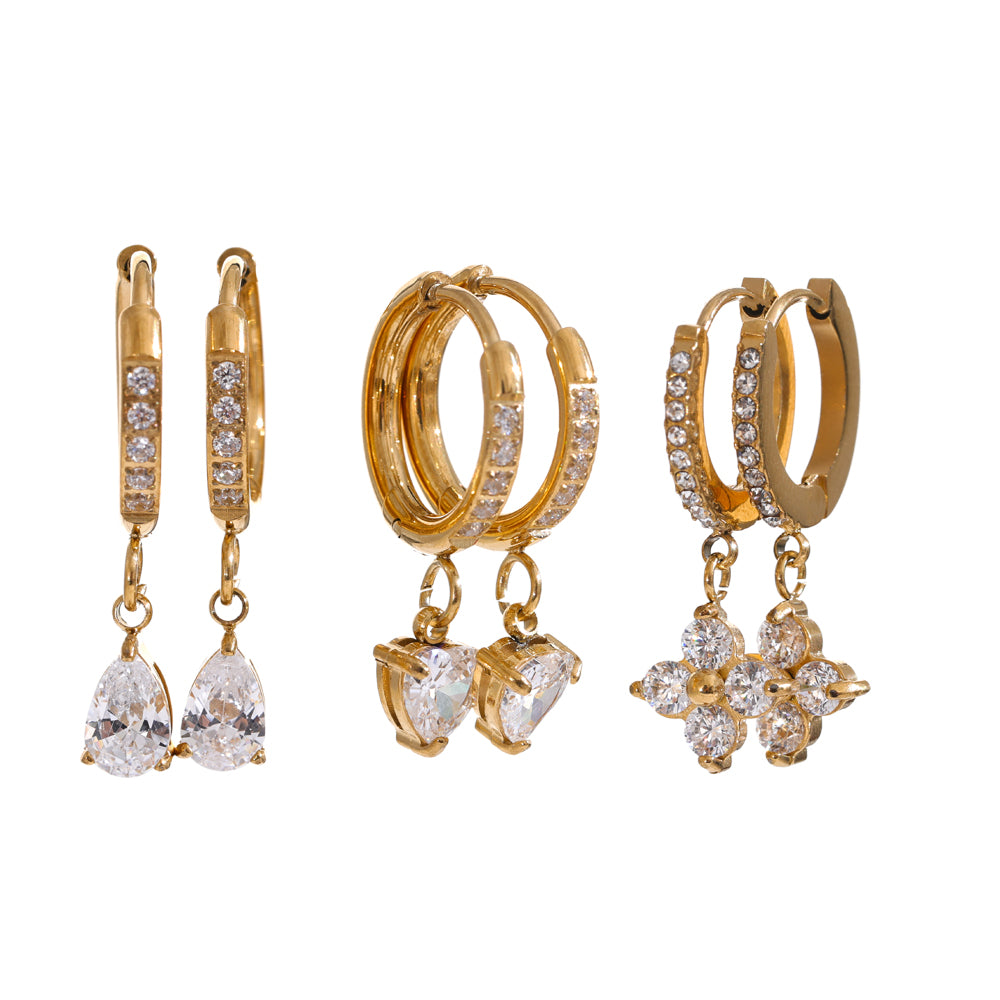 Set of gold hoop earrings with diamond accents on a white background