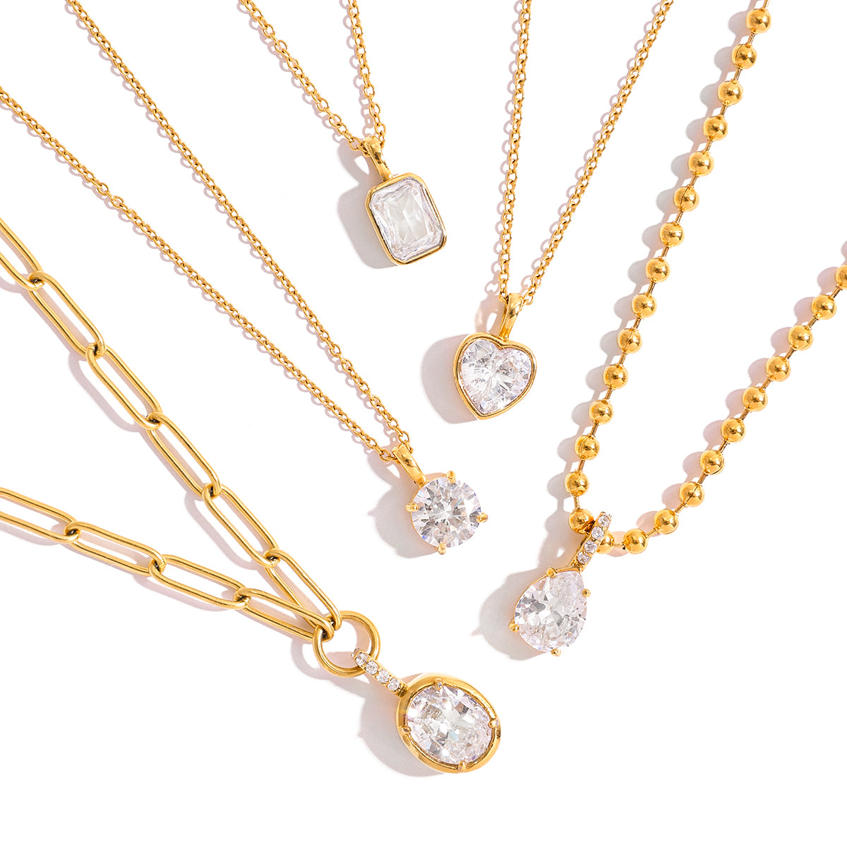 Gold necklaces with various pendants on a white background