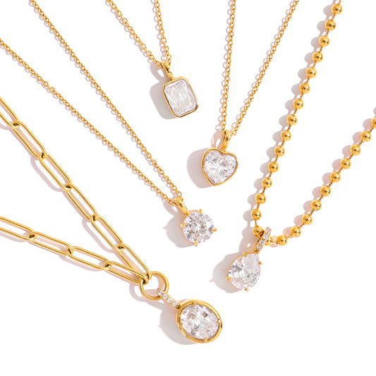 Gold necklaces with various pendants on a white background